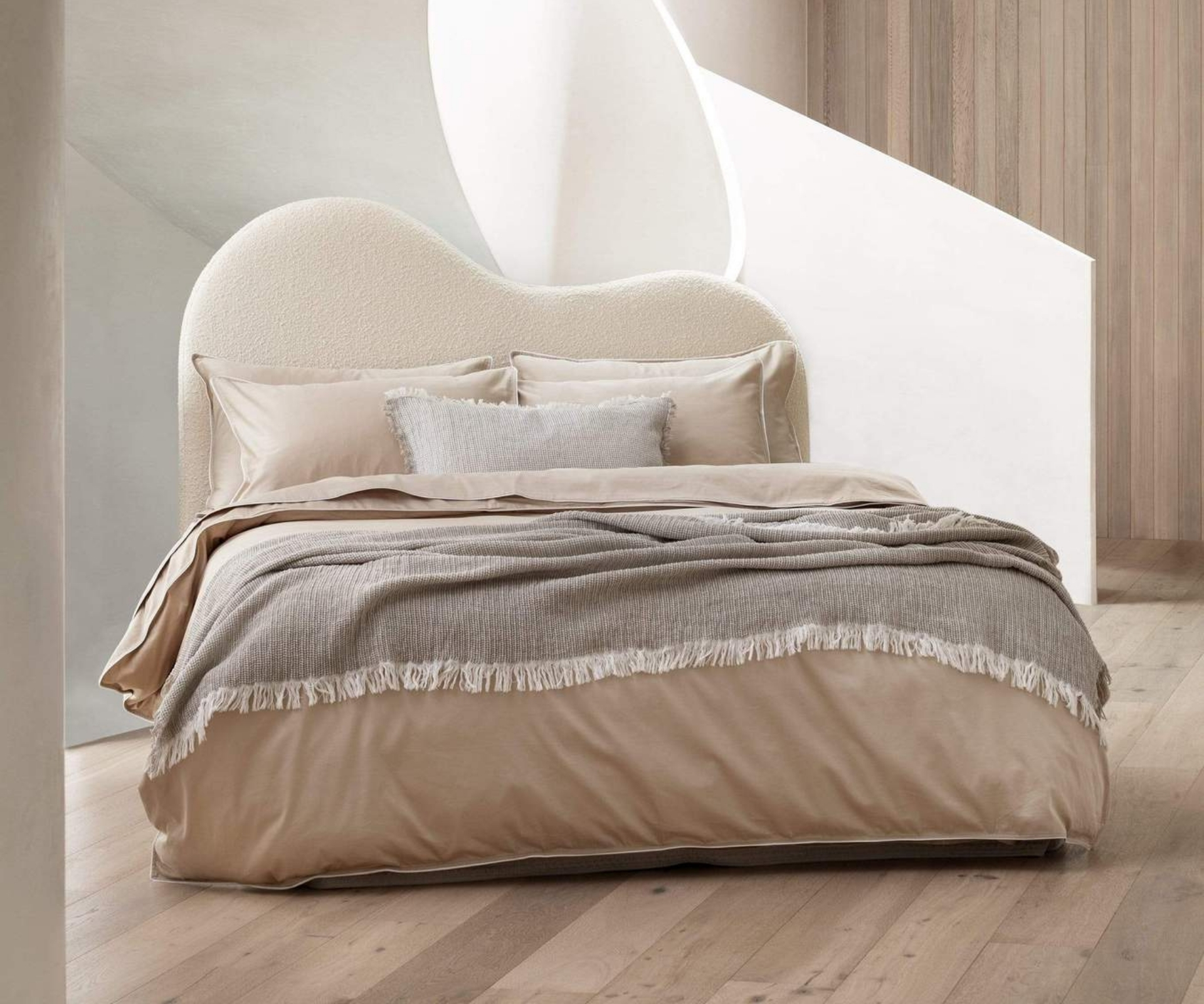 Neutral bed with a curved boucle bedhead