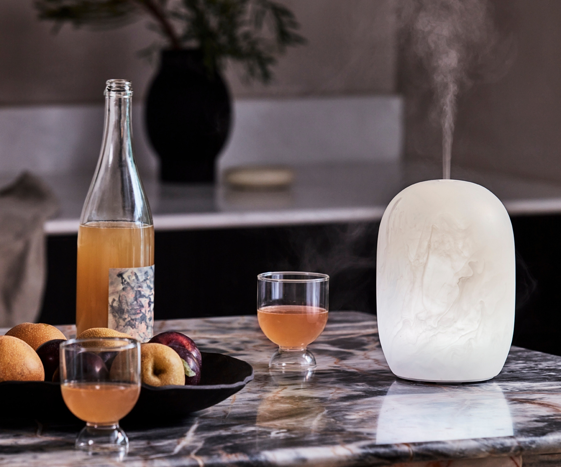 White resin diffuser on a kitchen bench next to cocktails