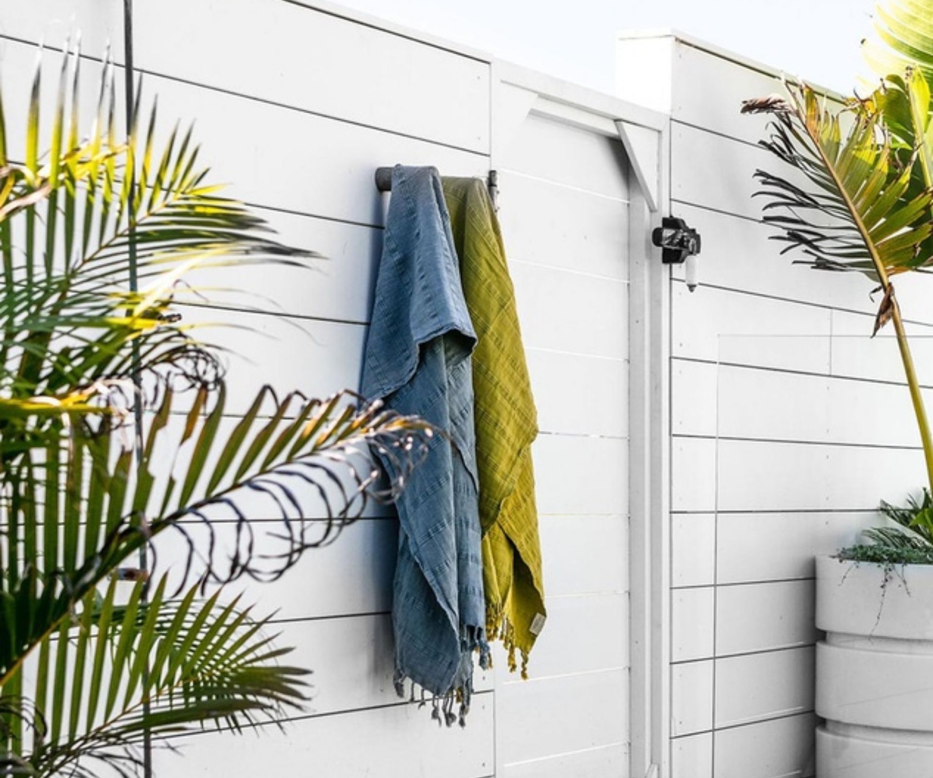 blue and green turkish towel hanging next to our outdoor shower
